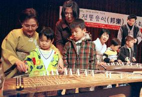 A Japanese koto player teaching Korean children